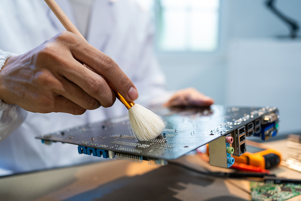 Technician cleaning a circuit board