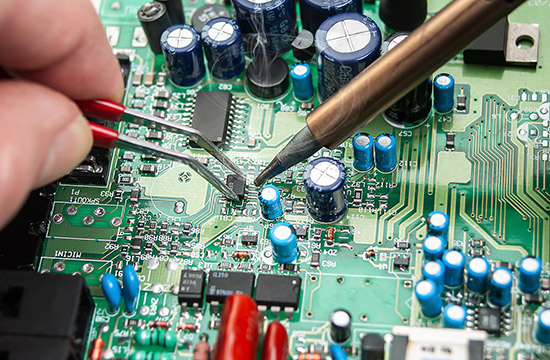 Technician soldering a circuit board Technician soldering a circuit board