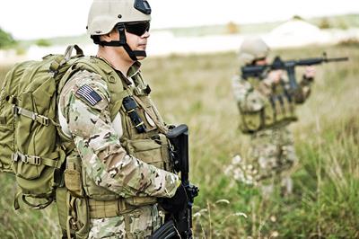 A soldier in protective gear on patrol.